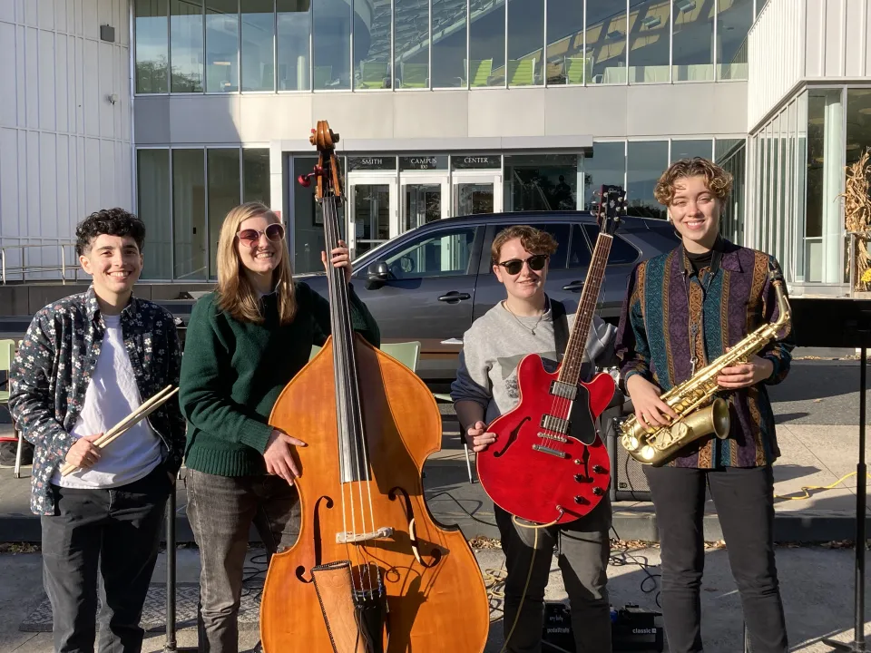 The Jazz Smiths with their instruments in the sunshine outside of the campus center