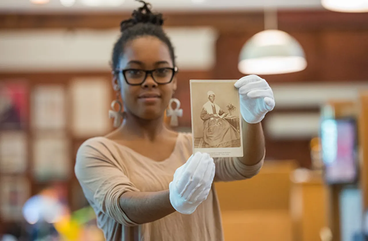 Student in Special Collections with photo of Otelia Cromwell