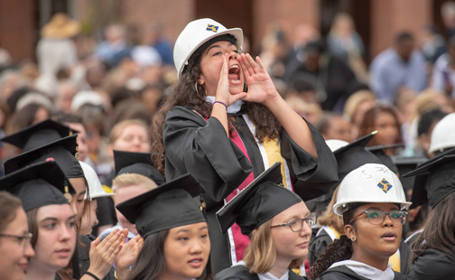 Someone in a graduation hard hat cheering