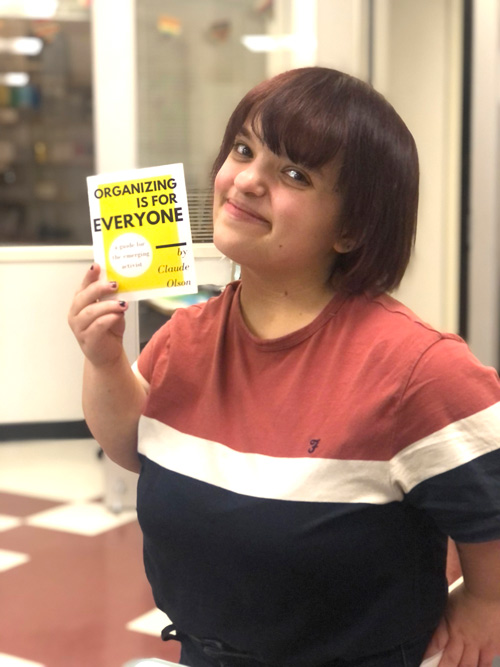 Claudia Olson holding a pamphlet entitled, "Organizing is for Everyone" by herself