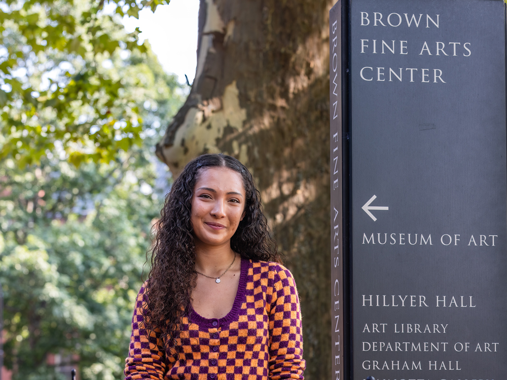 Maya Durham next to the Brown Fine Arts Center sign