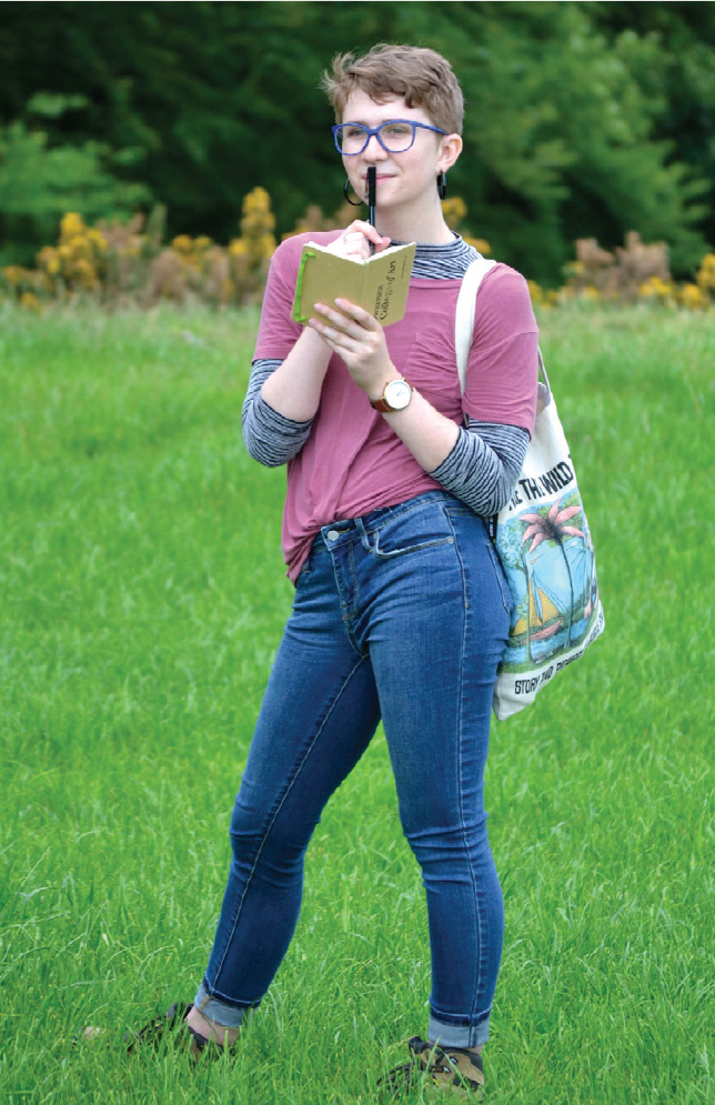 Sophie Willard Van-Sistine holding a notebook and pen, looking thoughtful
