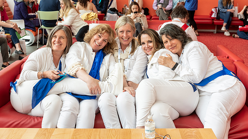 A group of alumnae sitting on a couch together in the Campus Center