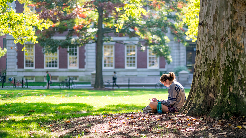 Student reading in front of Seelye Hall