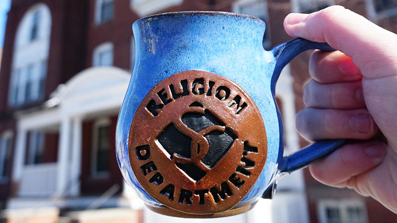 Blue pottery mug with the Smith College diamond and the words "Religion Department"