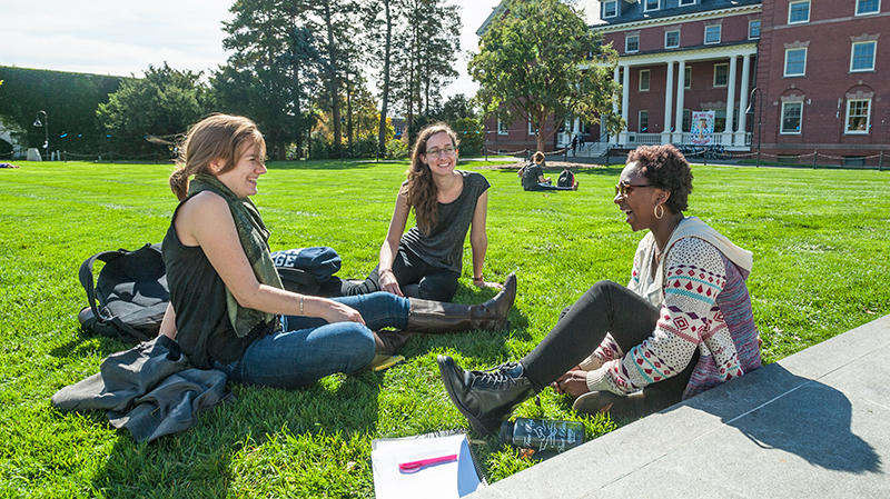Students sit on one of the many lawns on campus during a sunny day.