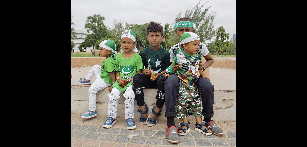 Photo of five Pakistani children sitting outside in a park
