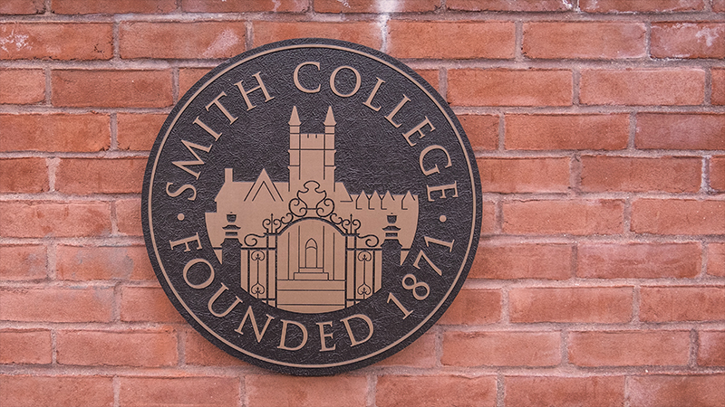 Photo of the college seal engraving on the entrance gates