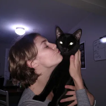 Kaylee Newbanks ‘24 kissing a black cat
