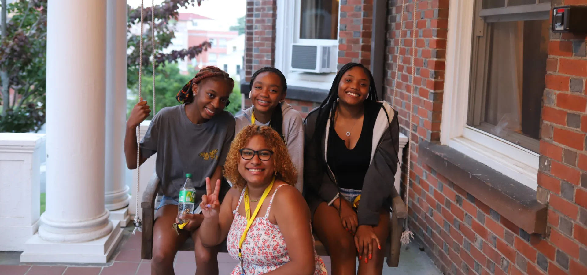 Four Precollege students on the front porch of a Smith house.