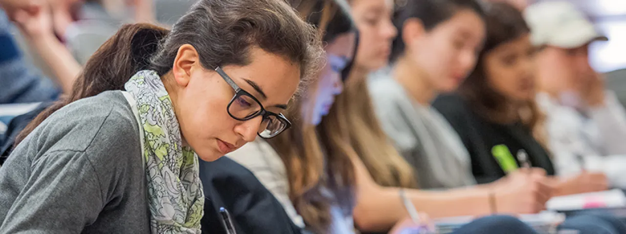 Smith student writing in a crowded classroom