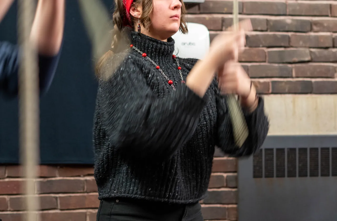 Change ringing in the Mendenhall Bell Tower with a student wearing a red bandana pulling a rope