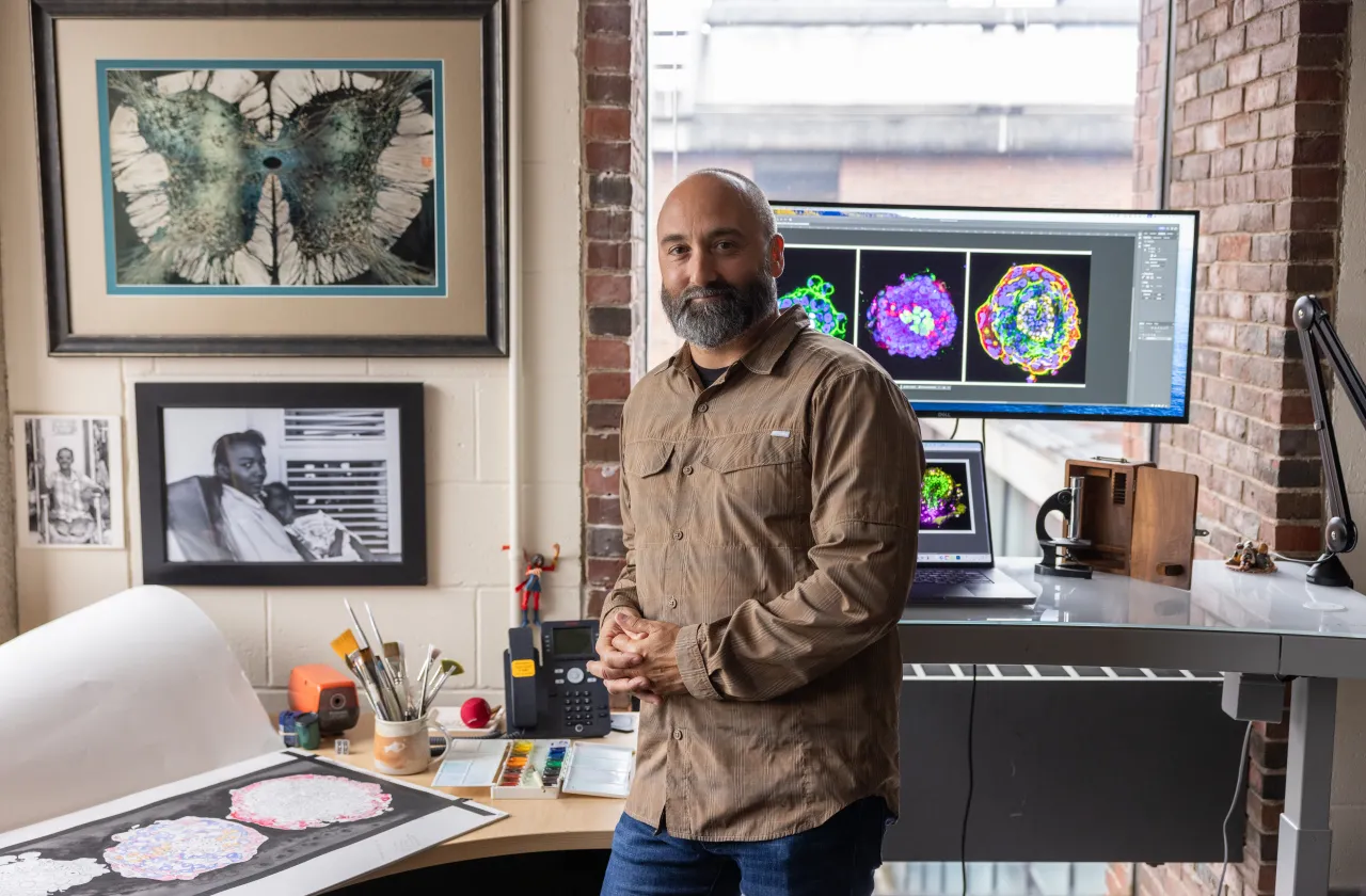 Michael Barresi in front of computer screens and an art pad.