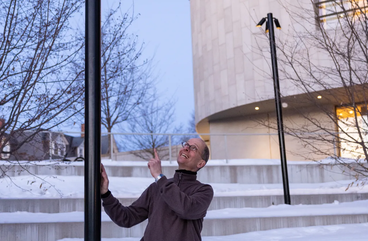 Astronomy Professor James Lowenthal stands near a night sky-friendly light behind the Smith library