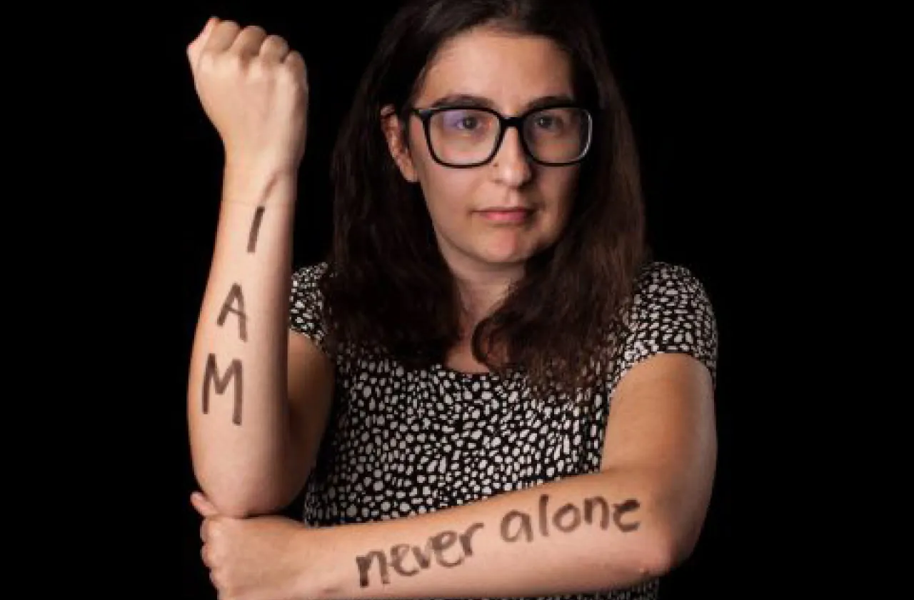 Becca Damante '17 with the words "I Am Never Alone" marked on her arms