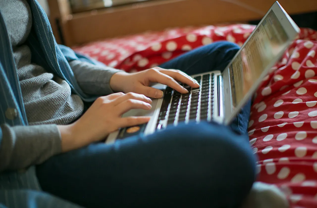 Closeup of a student typing on a laptop