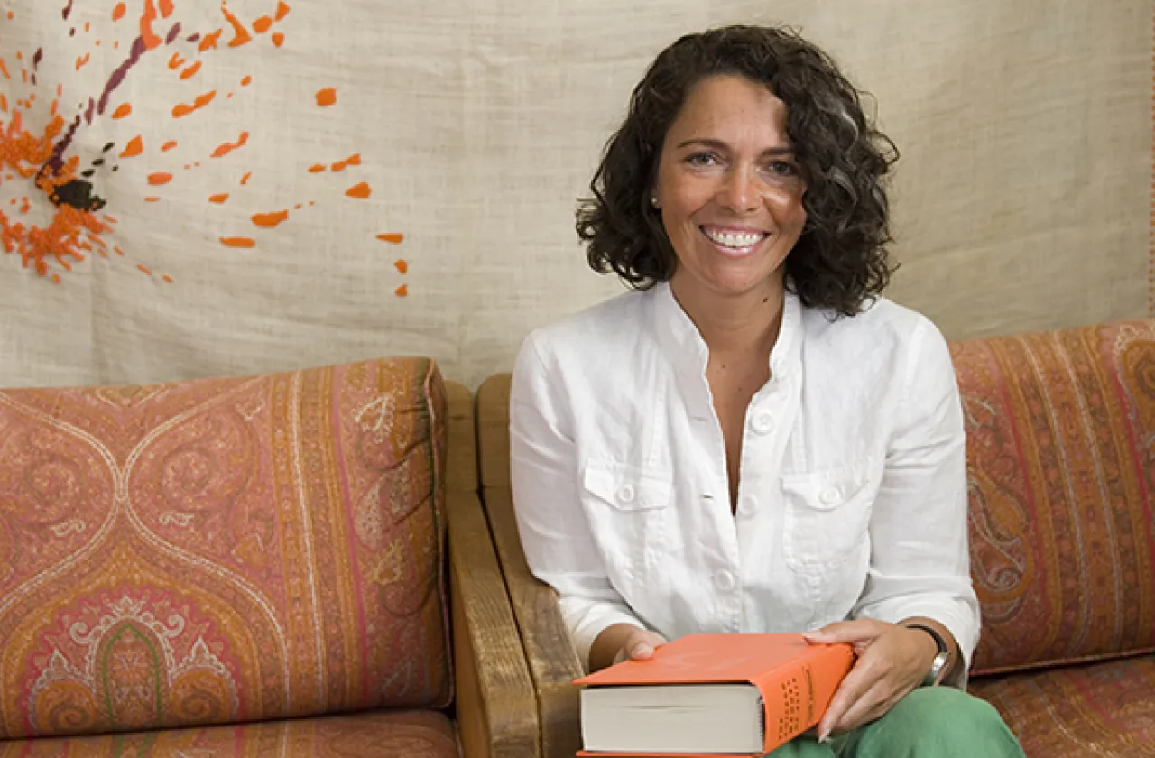 Photo of a woman sitting on a couch holding a book