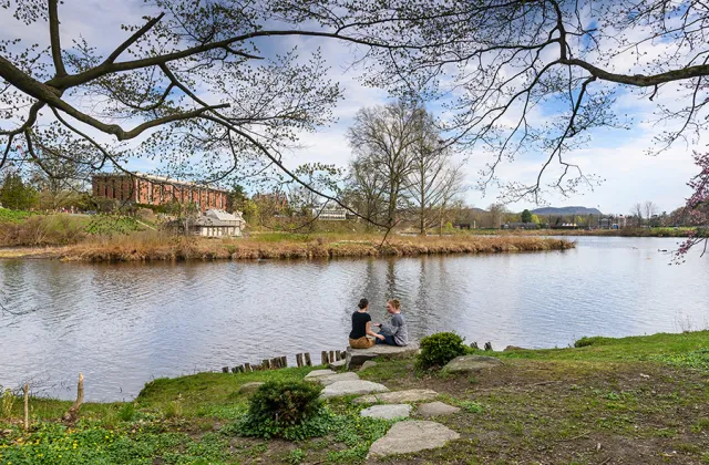 Two students sitting by Paradise Pond