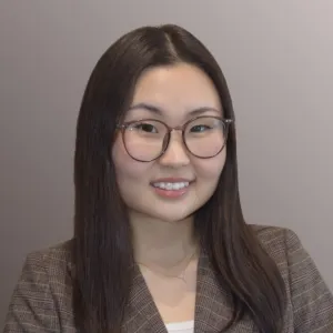 Headshot of Marla Amarsaikhan wearing round glasses and a plaid blazer.