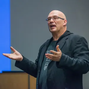 Frazer Ward speaking and demonstrating with his hands in front of a class