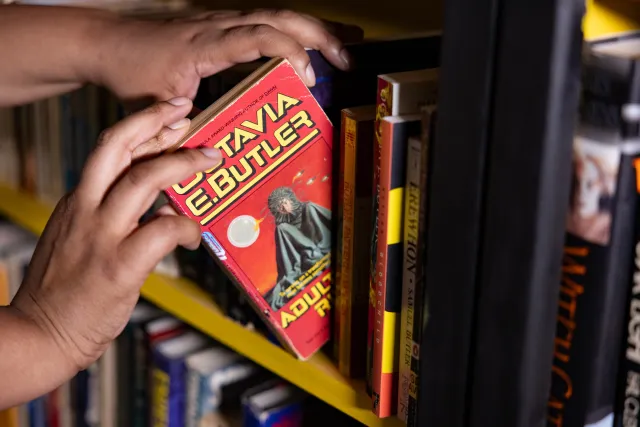 Anne-Marie Martin '26 takes a copy of Octavia Butler's "Adulthood Rites" off a bookshelf.