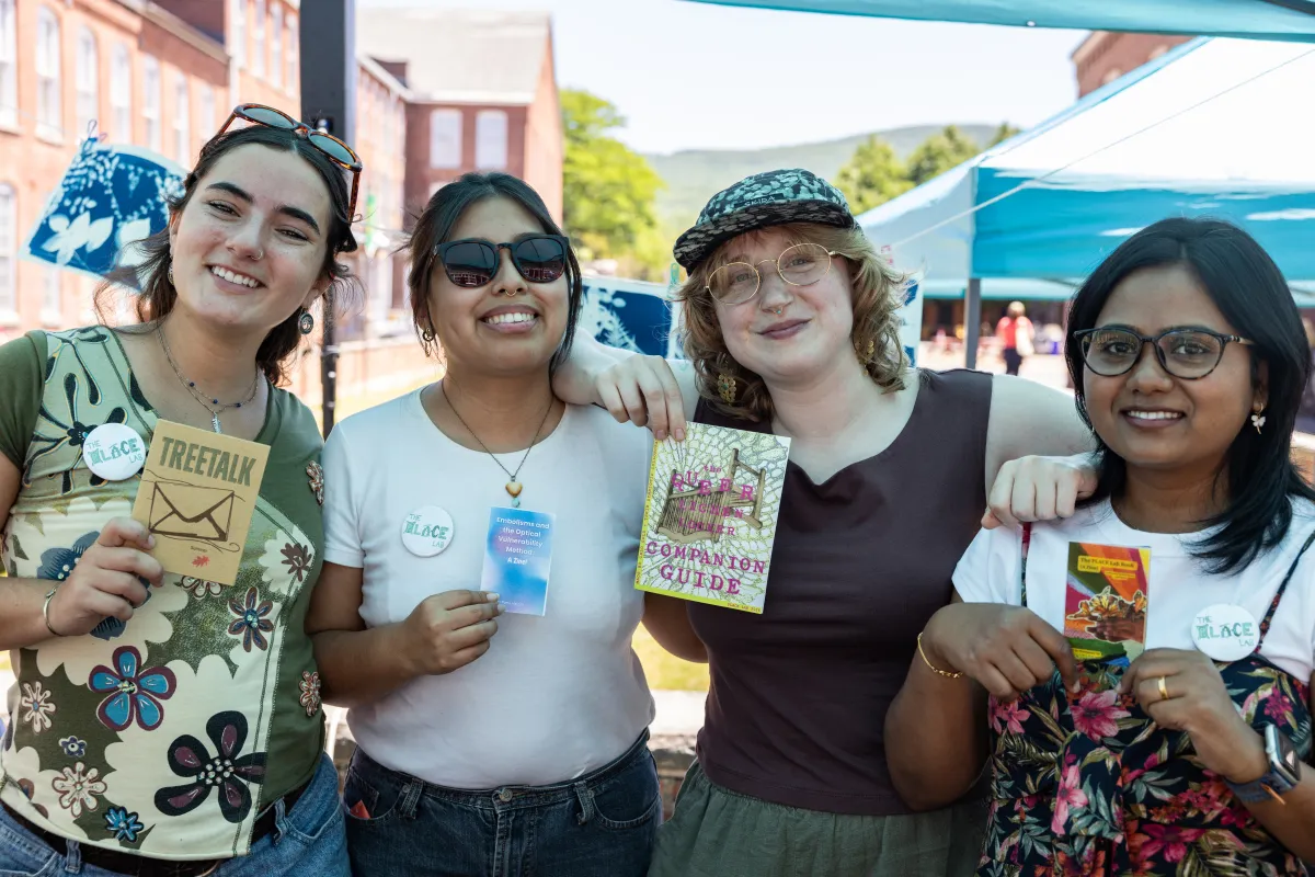 Smith students hold up the zines made for the exhibit.