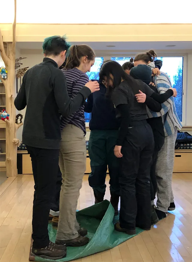 Students standing together on a green tarp