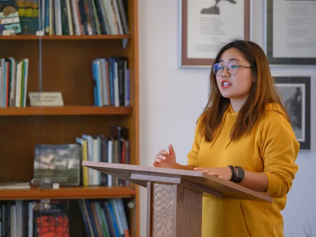A student reading a poem at a podium