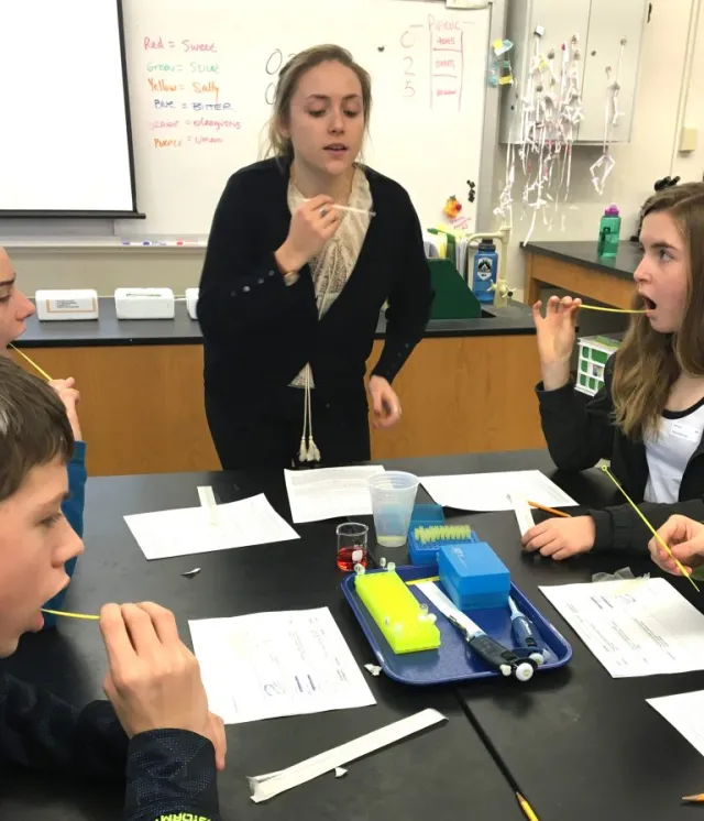 Haley Barravecchia ’18, shows Northampton High School students how to collect cheek cell samples so they can analyze their DNA.