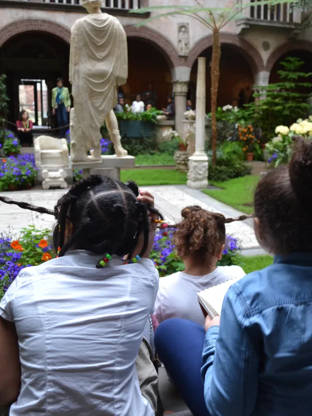 Children looking at a statue in a lush garden