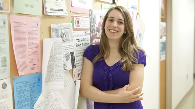 Student leaning against bulletin board