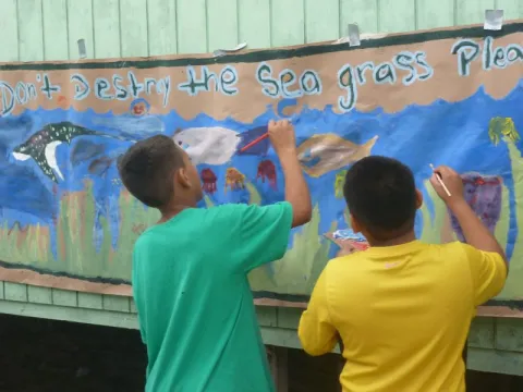 kids painting "Don't destroy the sea grass please"