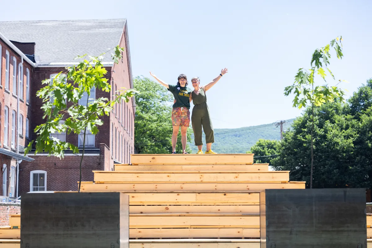 Jess Gersony and Amanda Lovelee stand atop the bleachers in between the two newly planted oak trees.