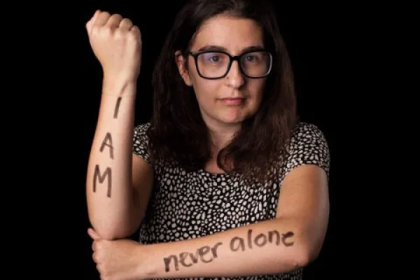 Becca Damante '17 with the words "I Am Never Alone" marked on her arms
