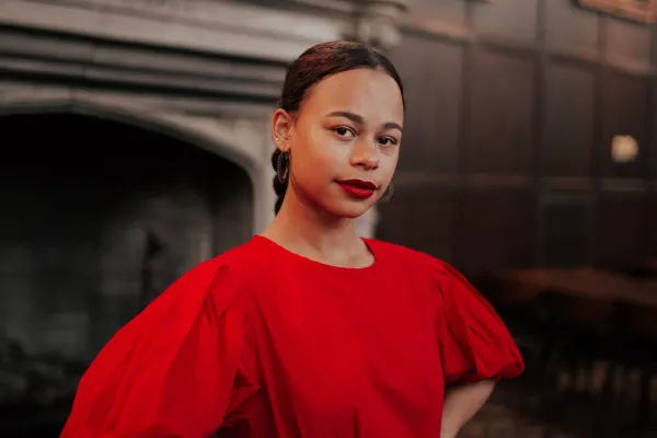 Camille Bacon in a red dress with red lipstick