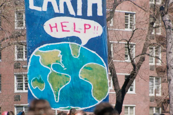 Earth Day 1970. A large banner with the globe saying "help" and EARTH in large letters. Below it is a large crowd.