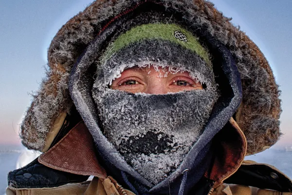 Marie McLane in many layers of warm clothes with ice on her scarf and hat, with only her eyes visible