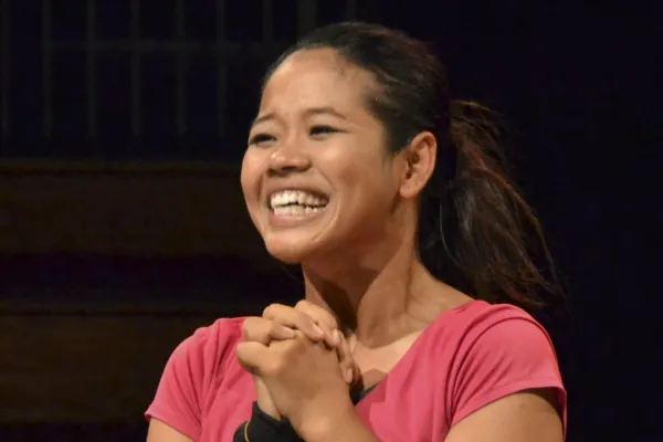 Phounam Pin smiling broadly on a stage