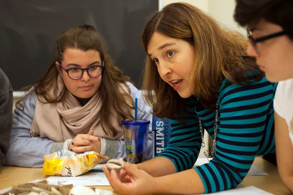 Sara Pruss leaning on table with students
