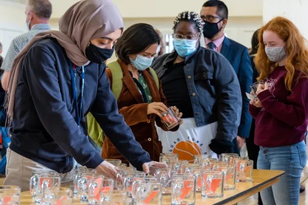 Staff and students picking up glass mugs