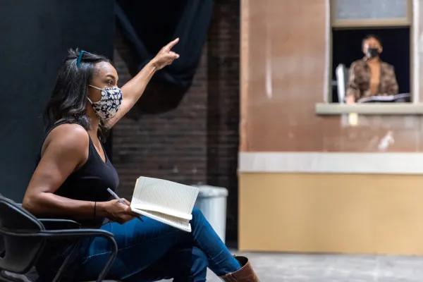 Director gesturing with an open screenplay in her lap