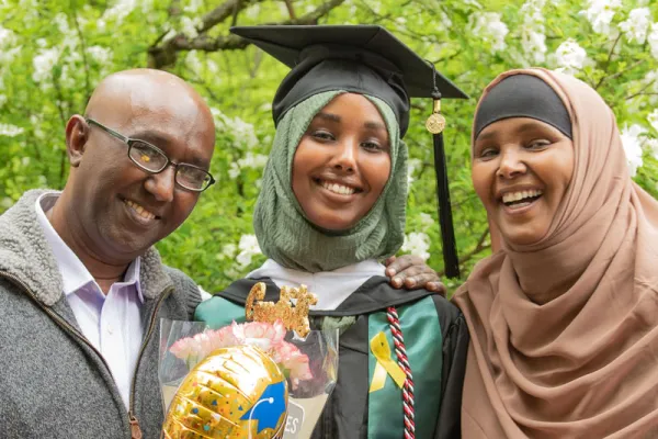 student in a hijab with her family at commencement