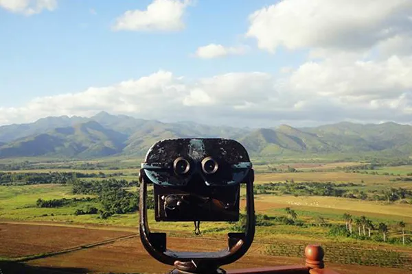 Viewfinder and panoramic view of a farm field, palm trees, and mountains