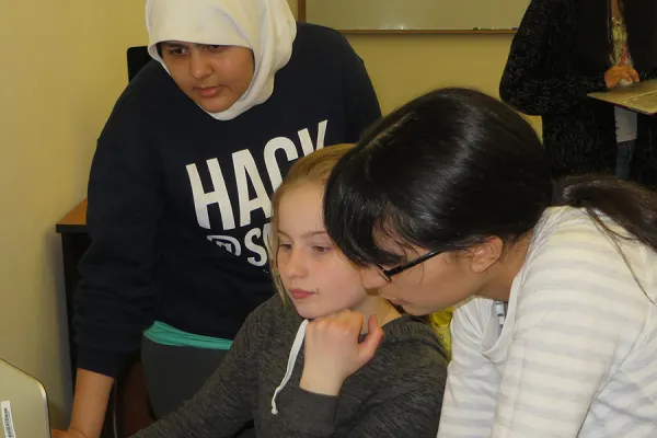 Girls Who Code members Zainab Aqdas Rizvi '18 (left) and Sharon Vizcaino De La Garza '17 (right) work with a middle school student on a coding problem.