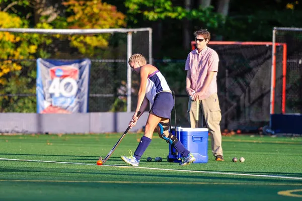 Katherine (Kat) Estes '16 warms up for a field hockey home game last season while physics professor Will Williams, faculty liaison to the team, looks on.