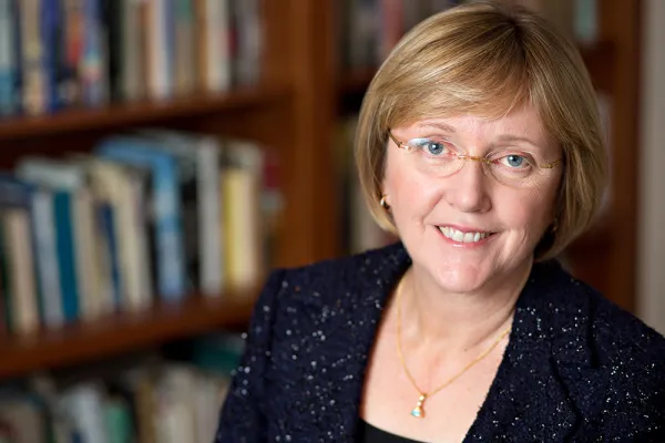 Kathleen McCartney in front of bookshelves