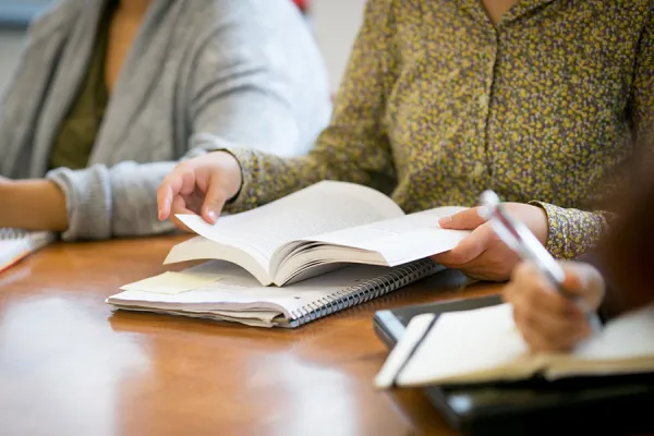 Closeup of a book being flipped open by a student