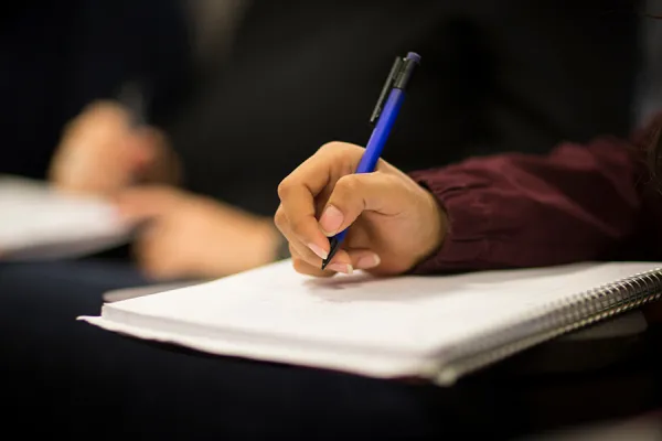 Closeup of a student writing in a notebook