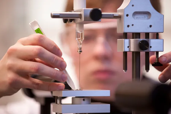 Closeup of a student's hands adjusting a scientific instrument