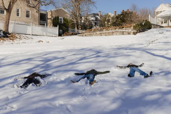 Three students creating snow angels